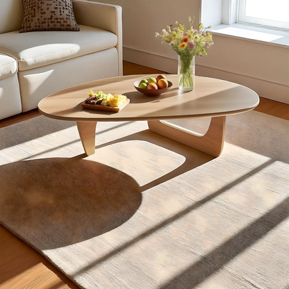 Minimalist round wooden coffee table, gently curved design combined with colors create a soft, cozy feeling 